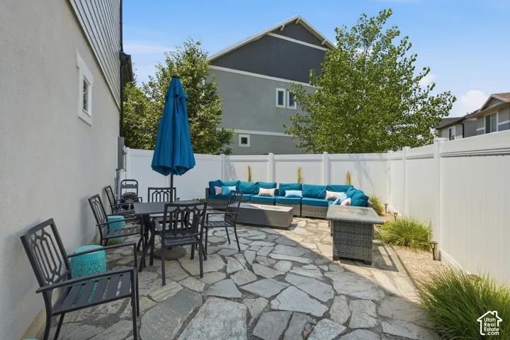 Flagstone patio with white privacy fencing, featuring a stucco-sided exterior and mature trees