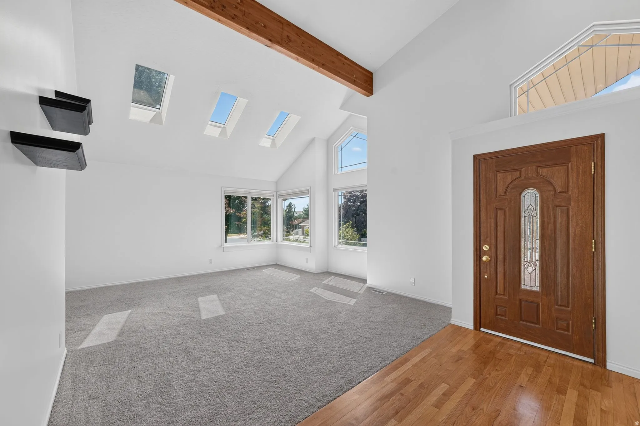 Vaulted ceilings with exposed wood beams and multiple skylights