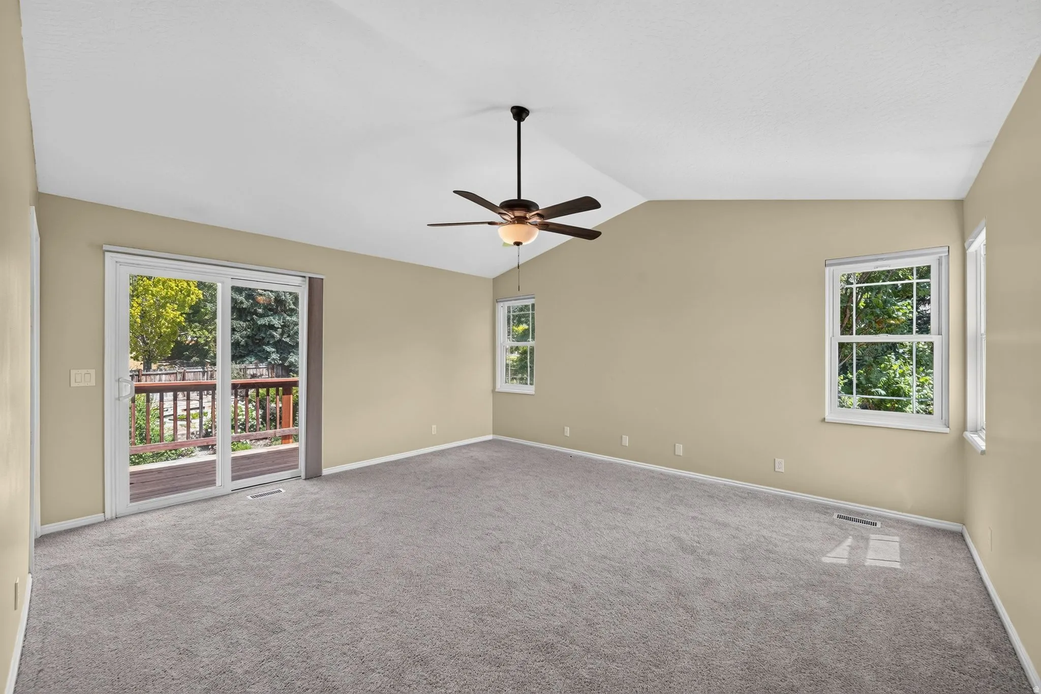 Spacious room with vaulted ceilings and neutral-toned walls
