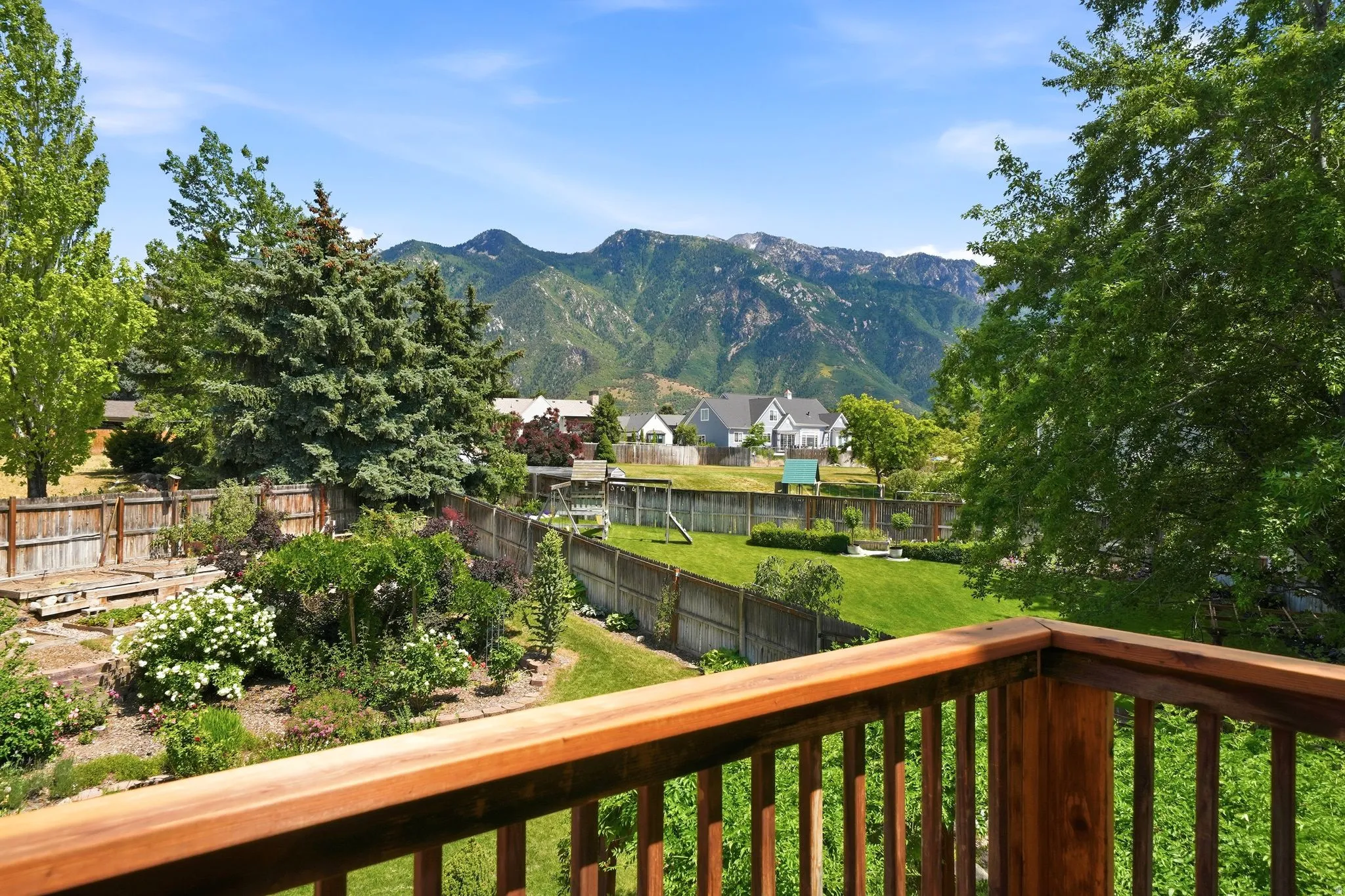 Expansive backyard featuring a tiered landscape, vibrant perennial plantings, and a manicured lawn
