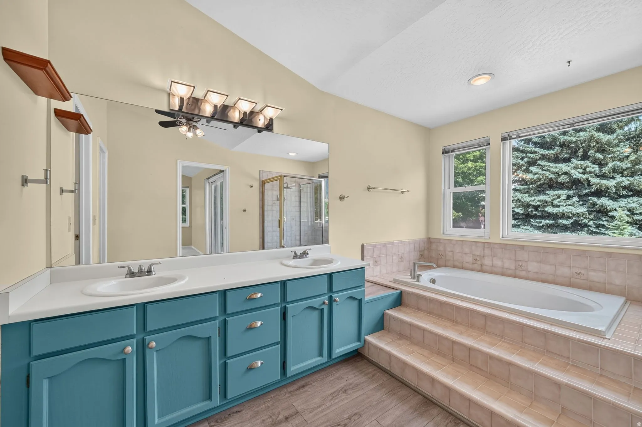 Dual vanity with white countertops, integrated sinks, and teal cabinetry