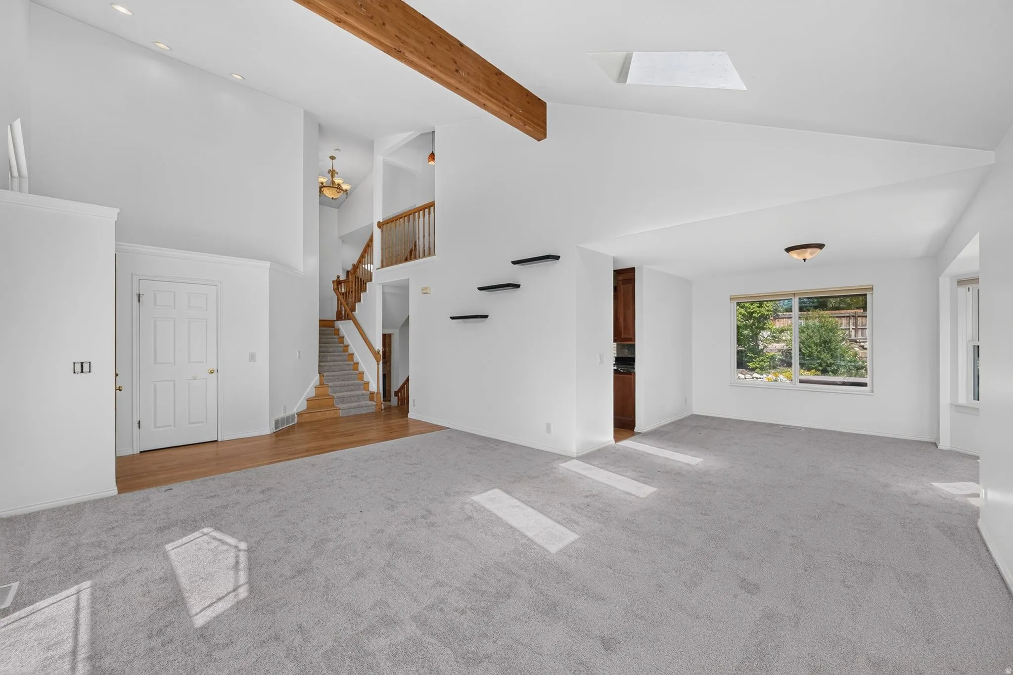Vaulted ceilings with exposed wood beams define this open-concept living area