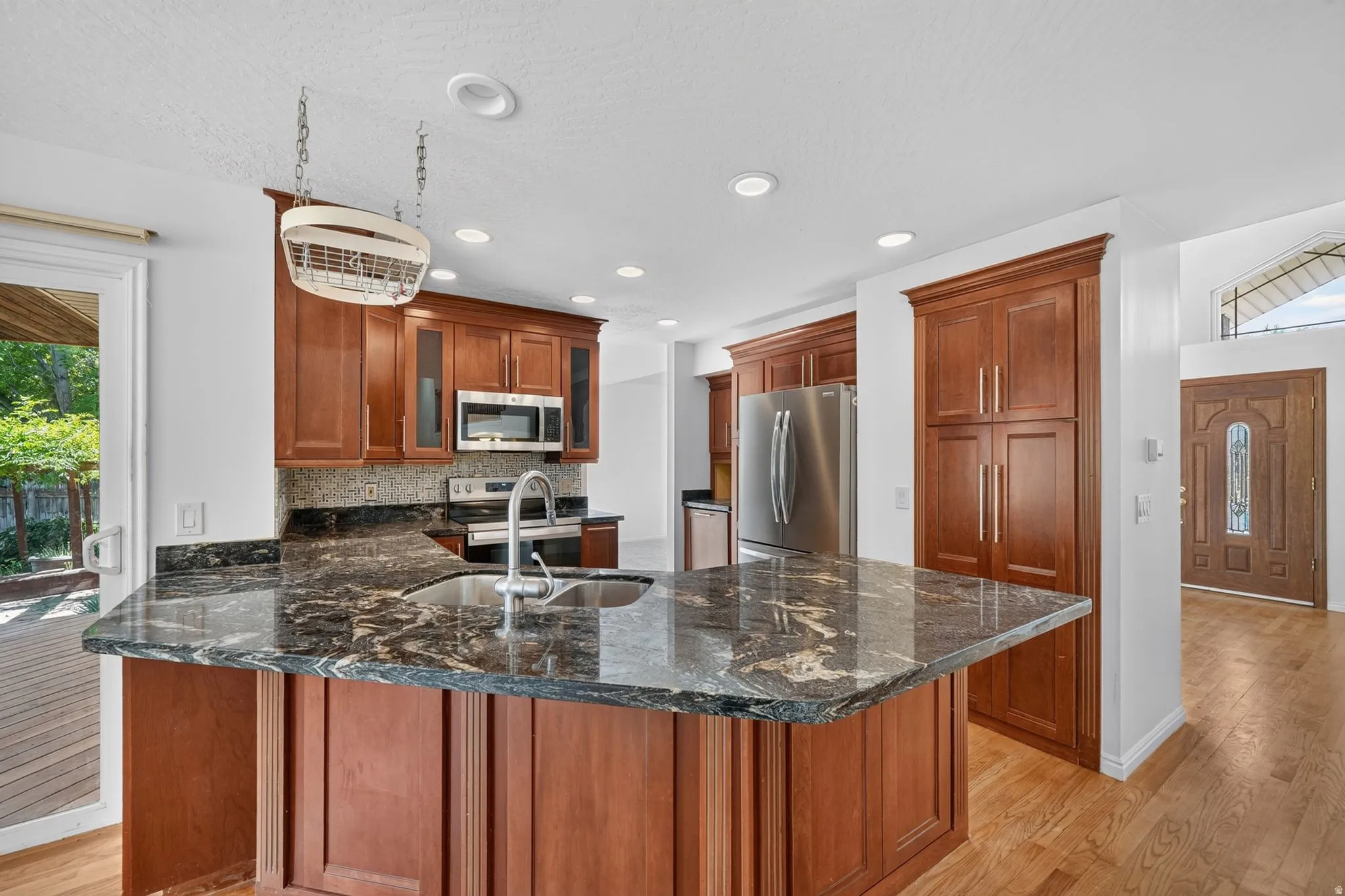 Kitchen island with a built-in sink and dark veined countertop