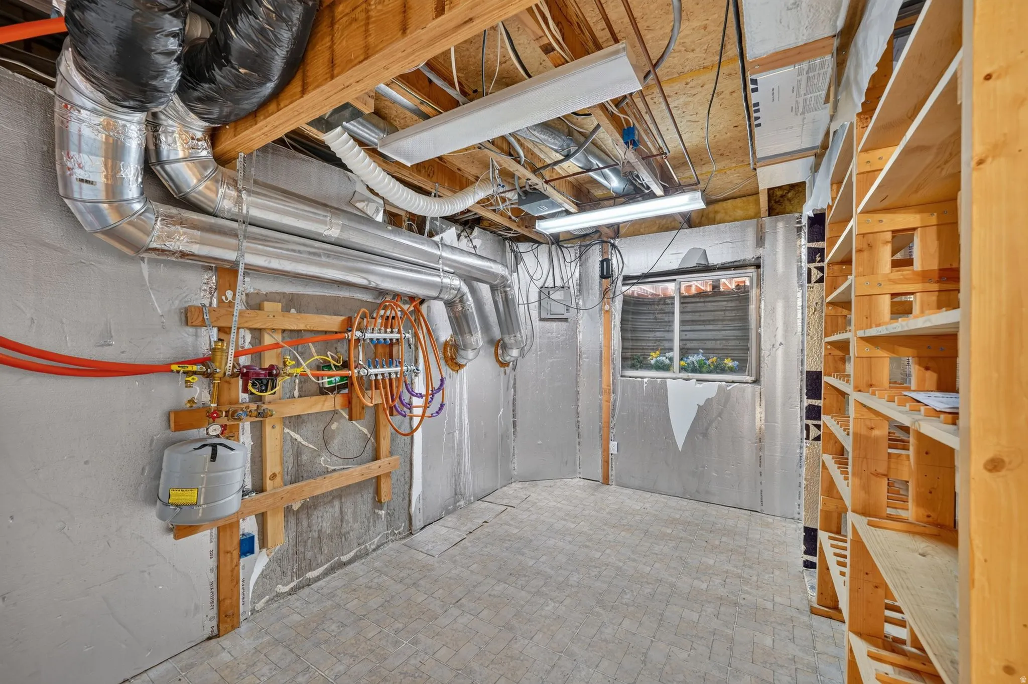 Utility room featuring exposed ceiling joists, ductwork, and built-in wooden shelving
