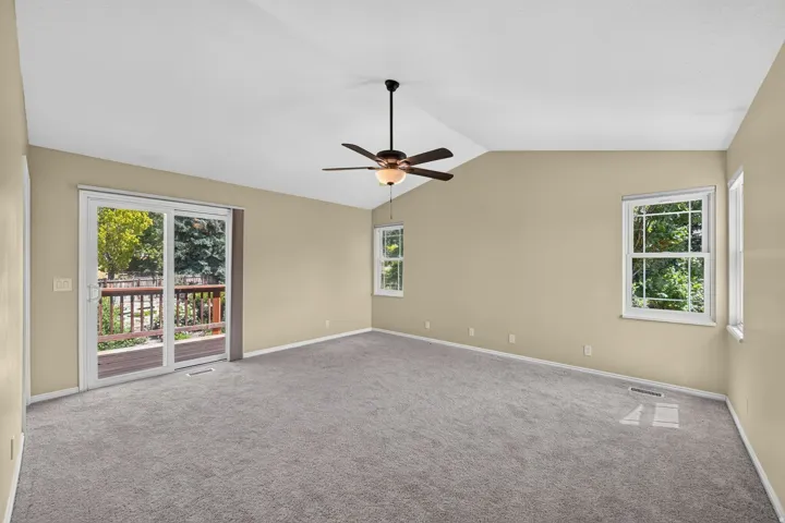 Spacious room with vaulted ceilings and neutral-toned walls