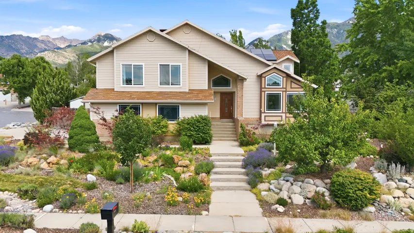 Two-story residence featuring light-colored siding and a multi-level front entrance