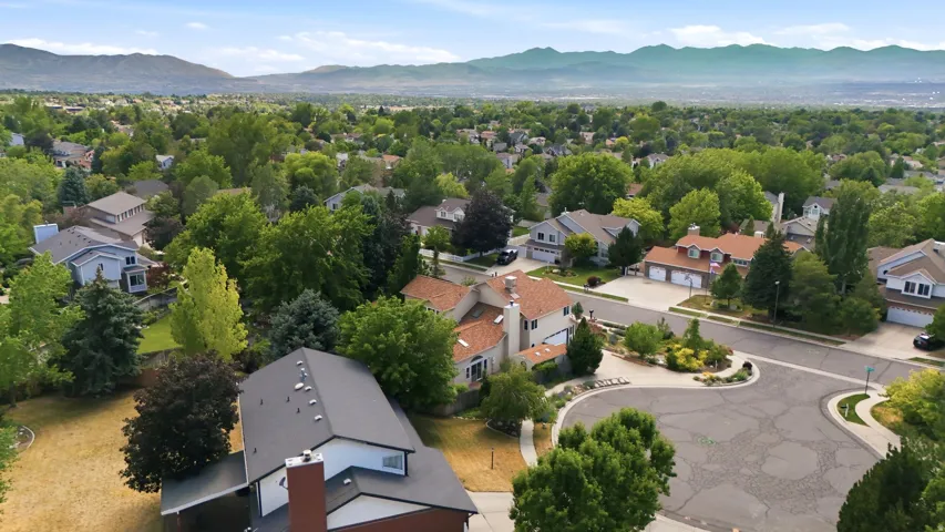 Residential neighborhood featuring mature trees, cul-de-sac street patterns, and mountain backdrops