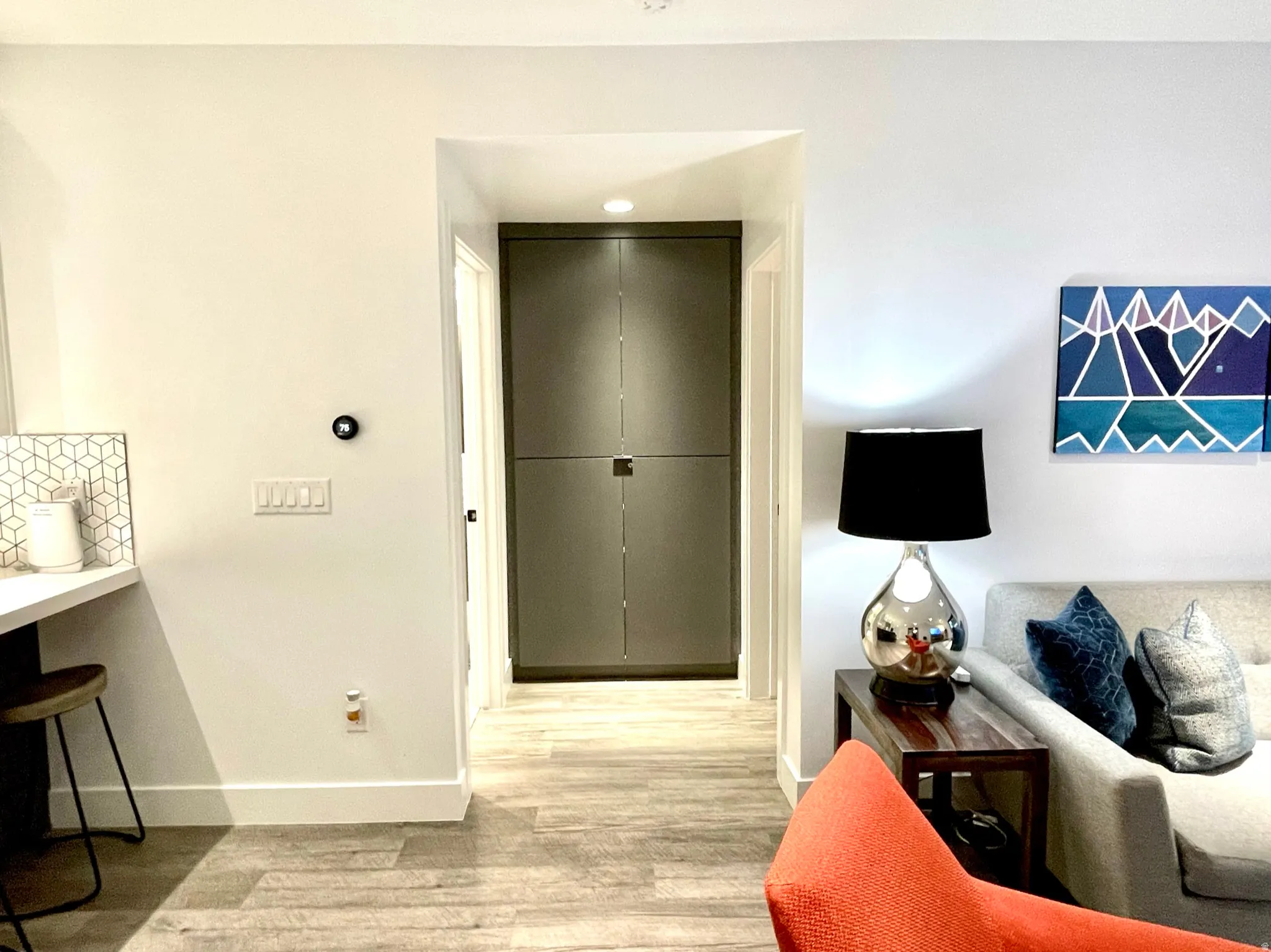 Hallway featuring built-in cabinetry, wood-finish flooring, recessed lighting, and a modern thermostat control