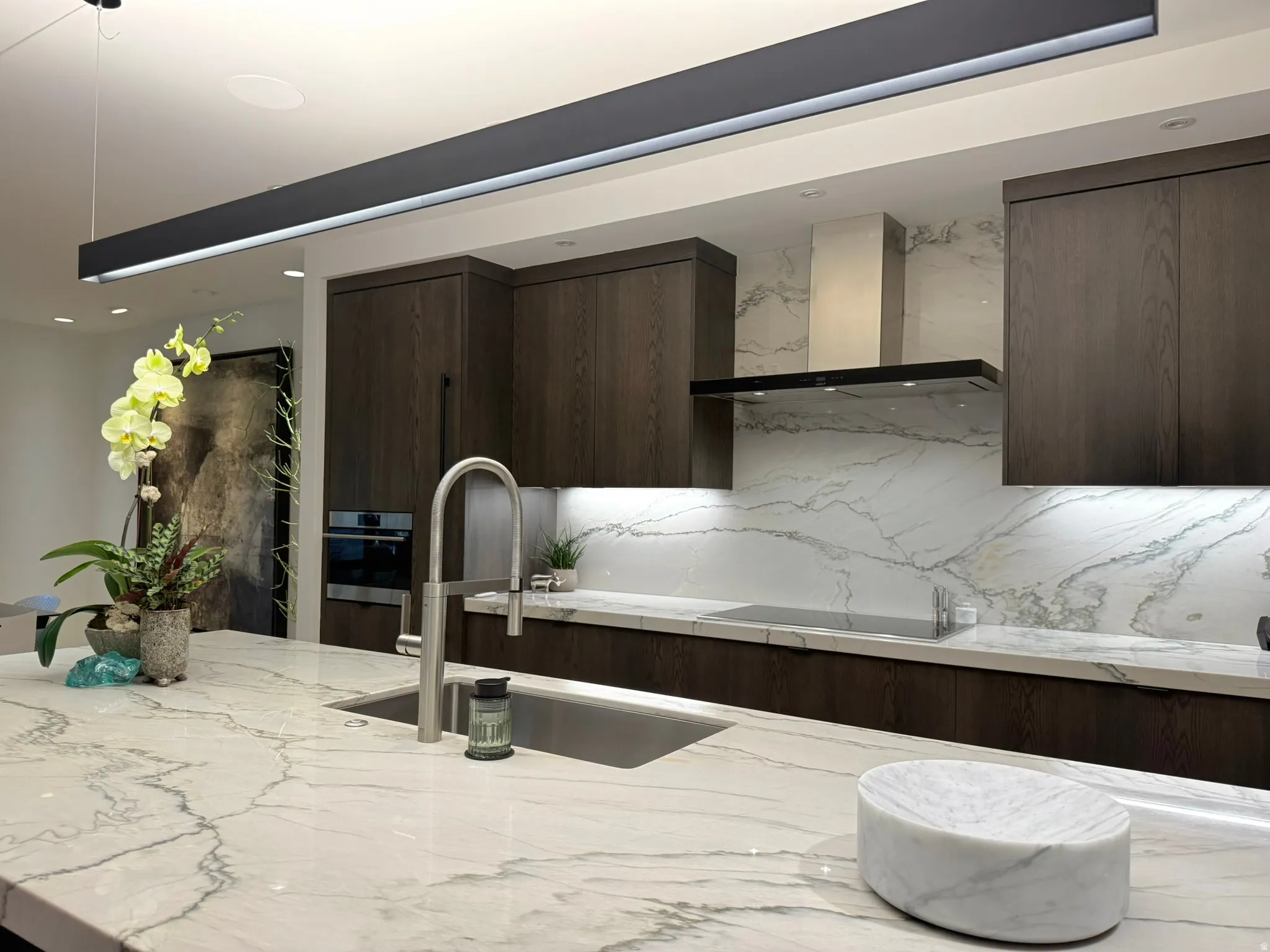 Kitchen featuring a large island with an undermount sink and gooseneck faucet
