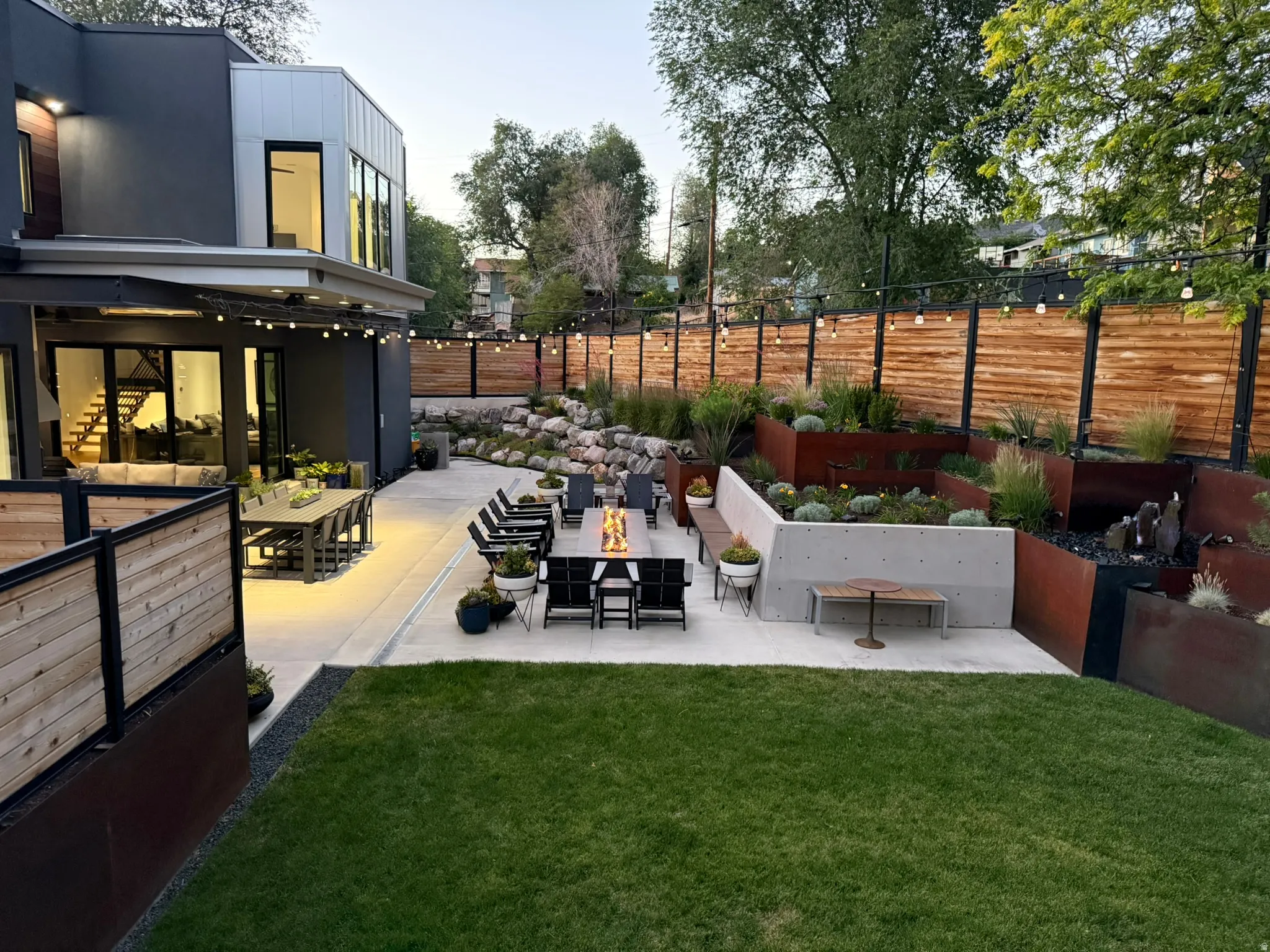 Expansive concrete patio with integrated fire pit, providing an outdoor entertaining space