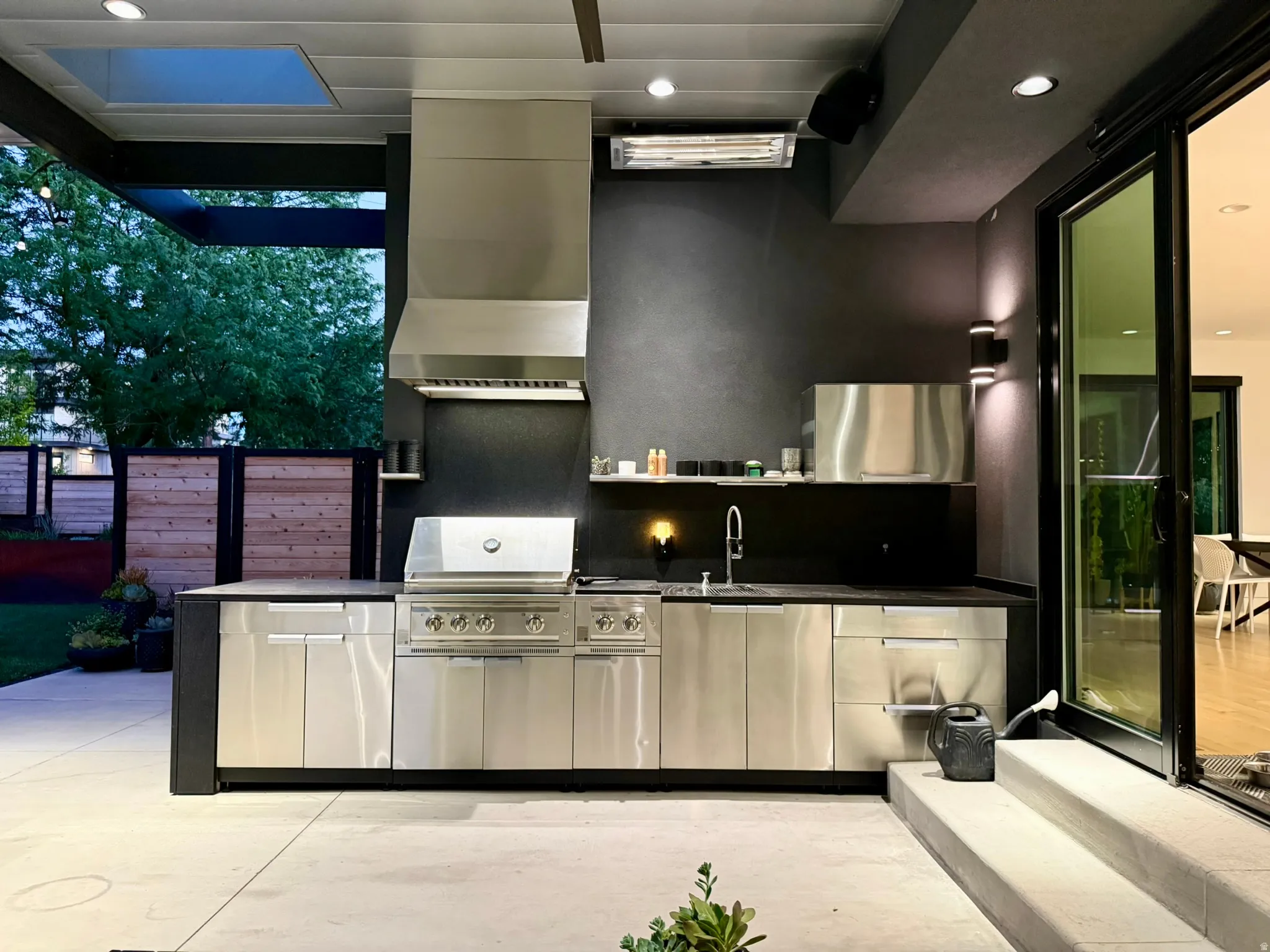 Outdoor kitchen featuring stainless steel cabinetry, an integrated grill, and a built-in sink
