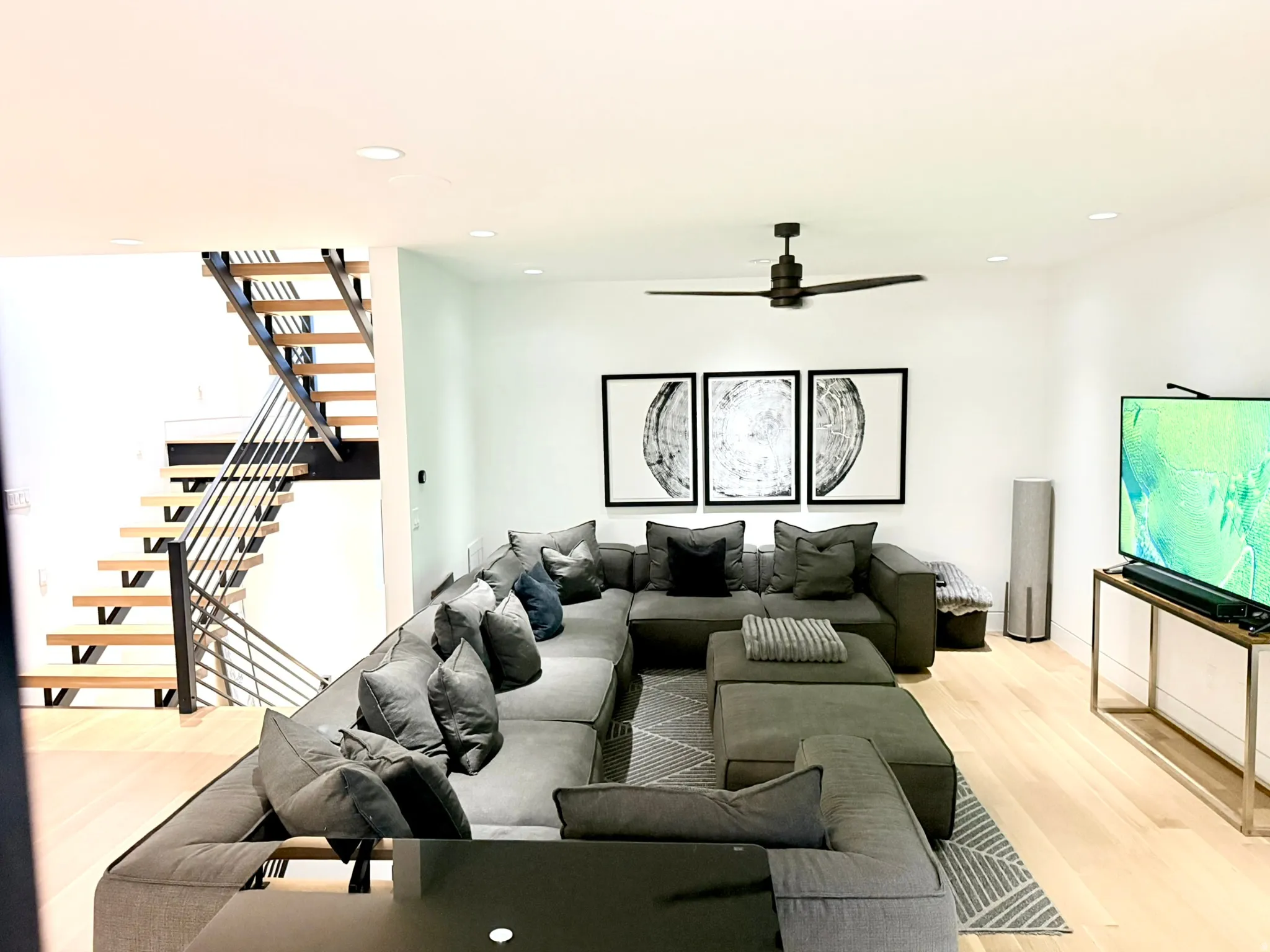 Open-concept living space featuring light wood-finish flooring, recessed lighting, and a contemporary ceiling fan