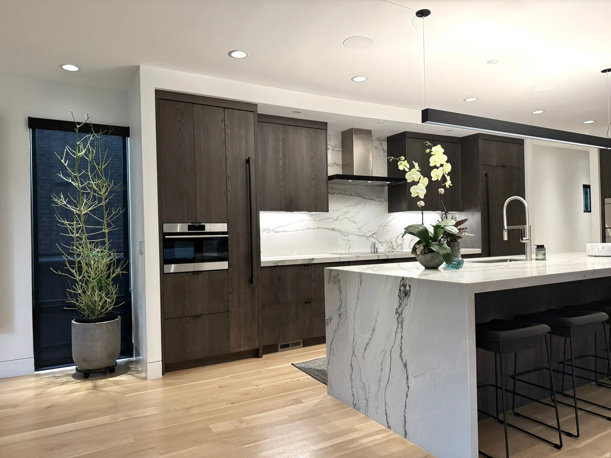 Gourmet kitchen featuring dark wood-finish cabinetry, an integrated refrigerator, and a built-in oven