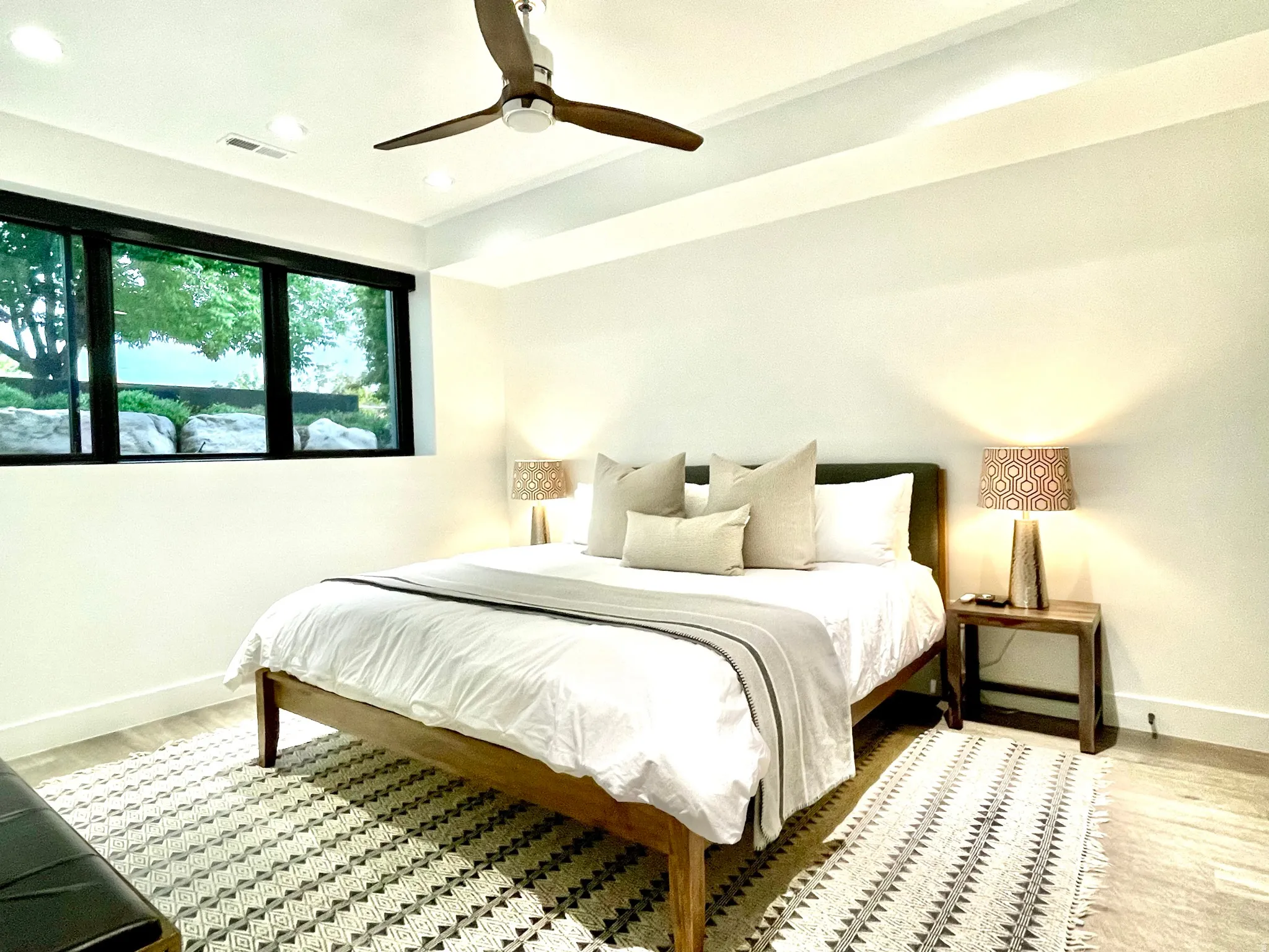 Spacious room featuring a contemporary ceiling fan, recessed lighting, and a large window with black framing