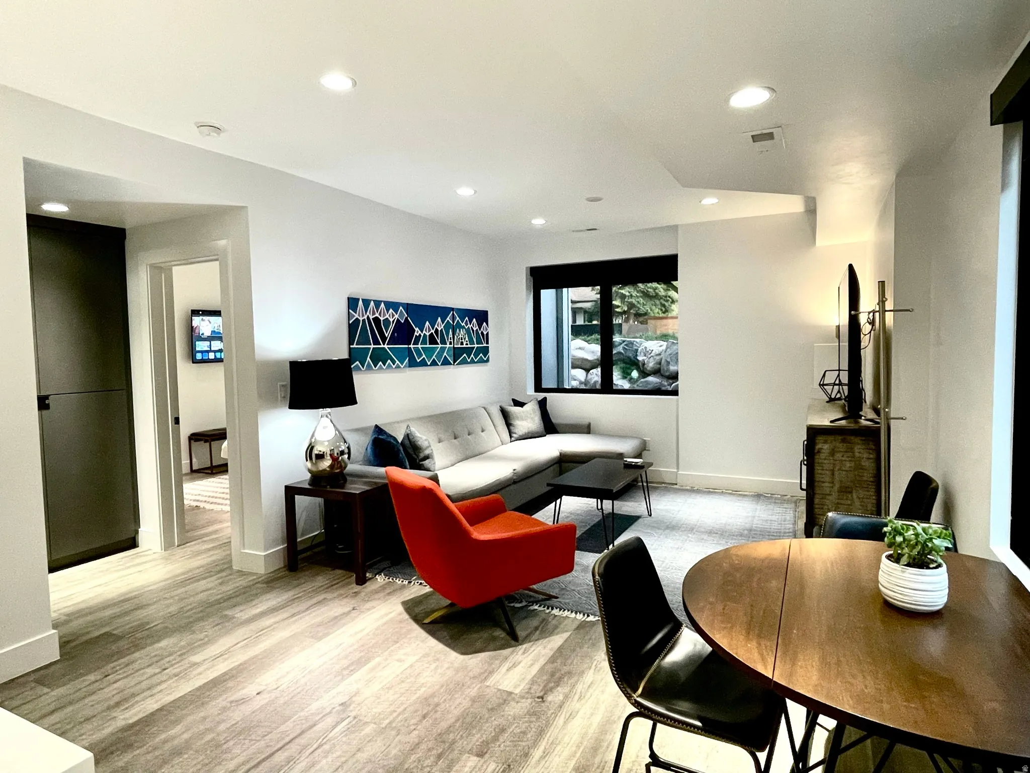 Open-concept living space featuring wood-finish flooring, recessed lighting, and white baseboards