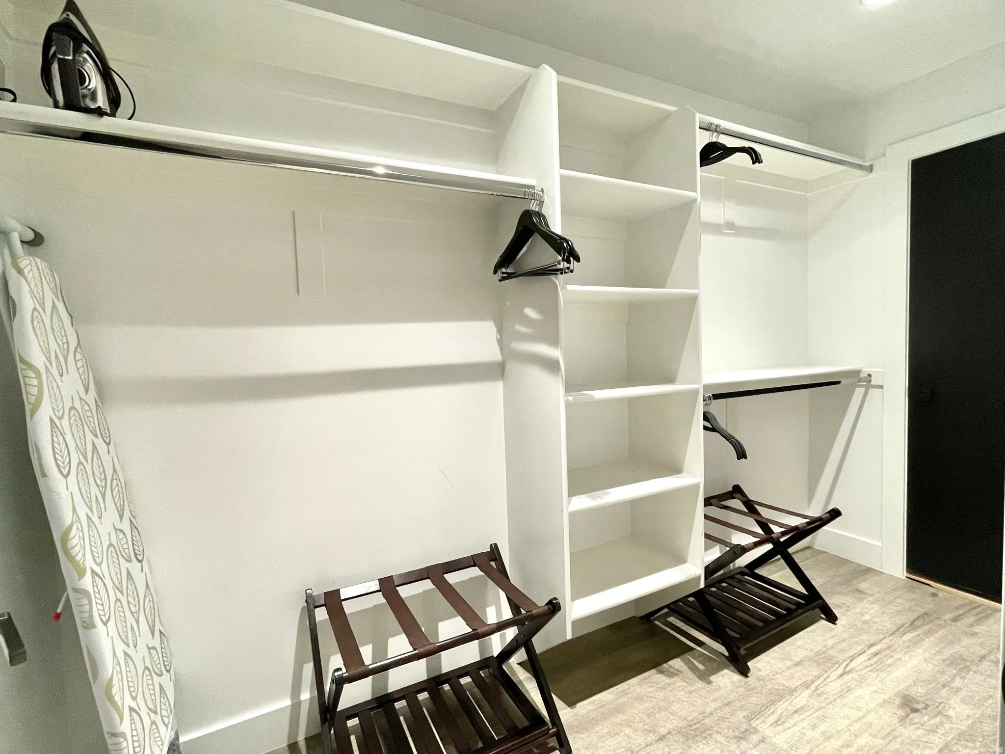 White built-in closet system featuring shelving and chrome hanging rods