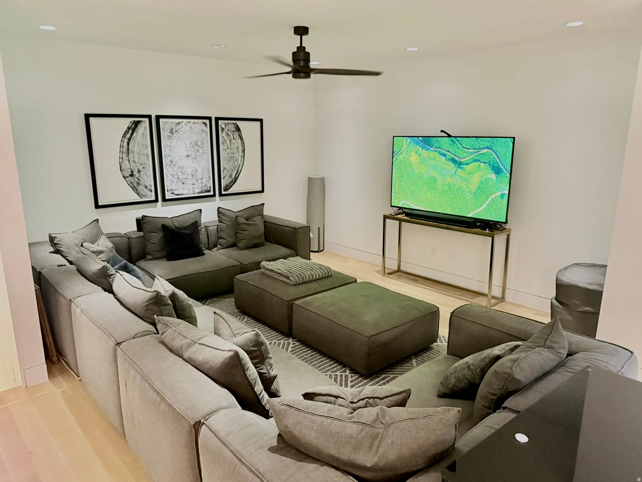 Spacious room featuring light wood-finish flooring, recessed lighting, and a modern ceiling fan