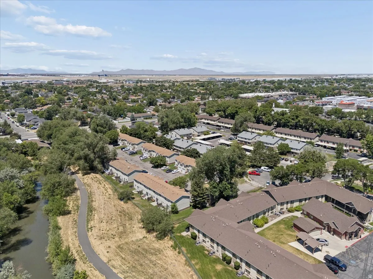 Aerial perspective showcasing a residential community with abundant mature trees and multiple multi-unit buildings