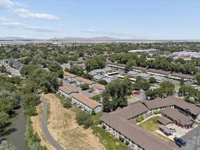 Aerial perspective showcasing a residential community with abundant mature trees and multiple multi-unit buildings
