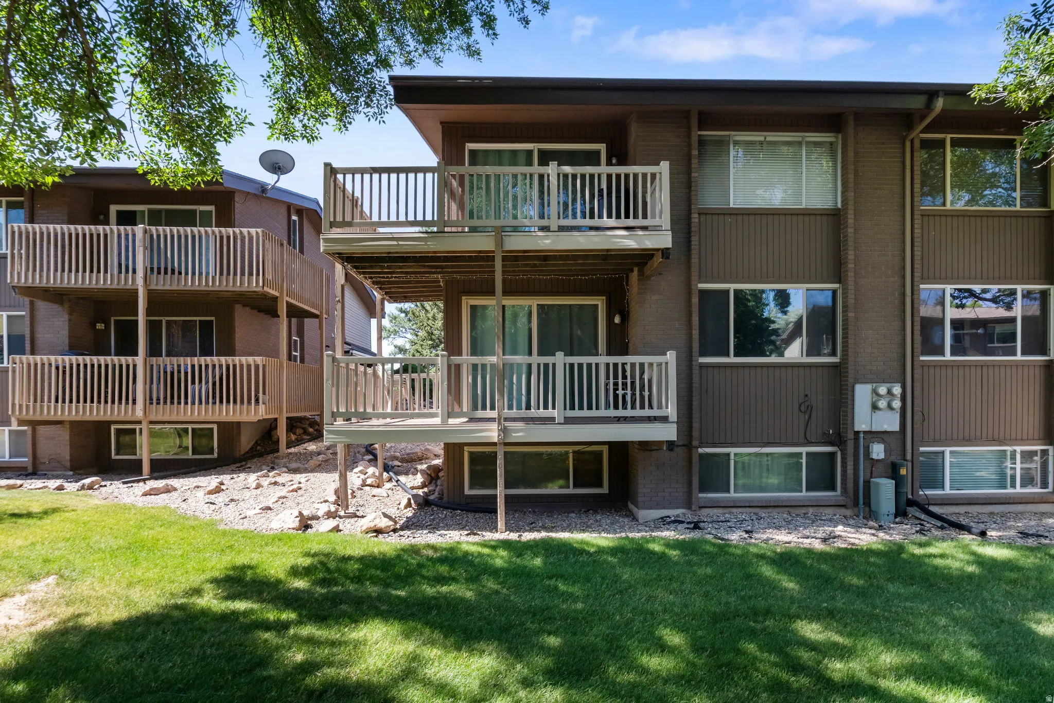 Multi-level residential building featuring wood-sided exterior and multiple private balconies with wood railings
