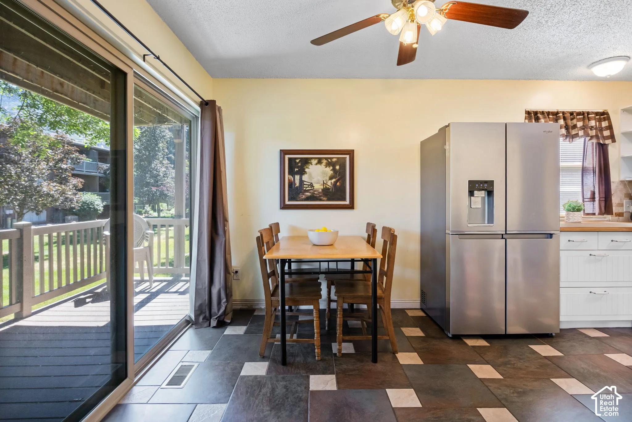 Dining area featuring patterned tile flooring and a ceiling fan with integrated lighting