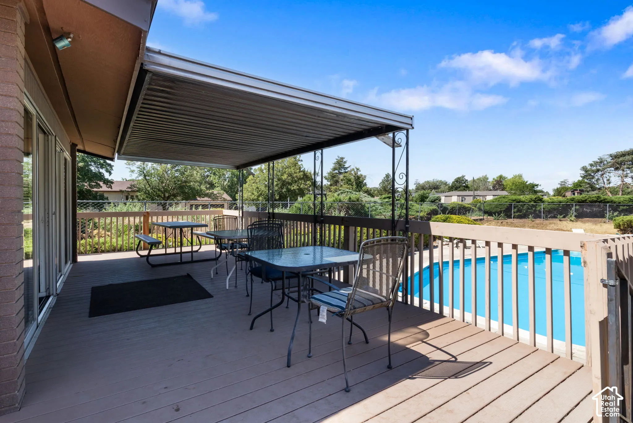 Expansive outdoor deck featuring a covered patio, wood-finish decking, and a perimeter railing