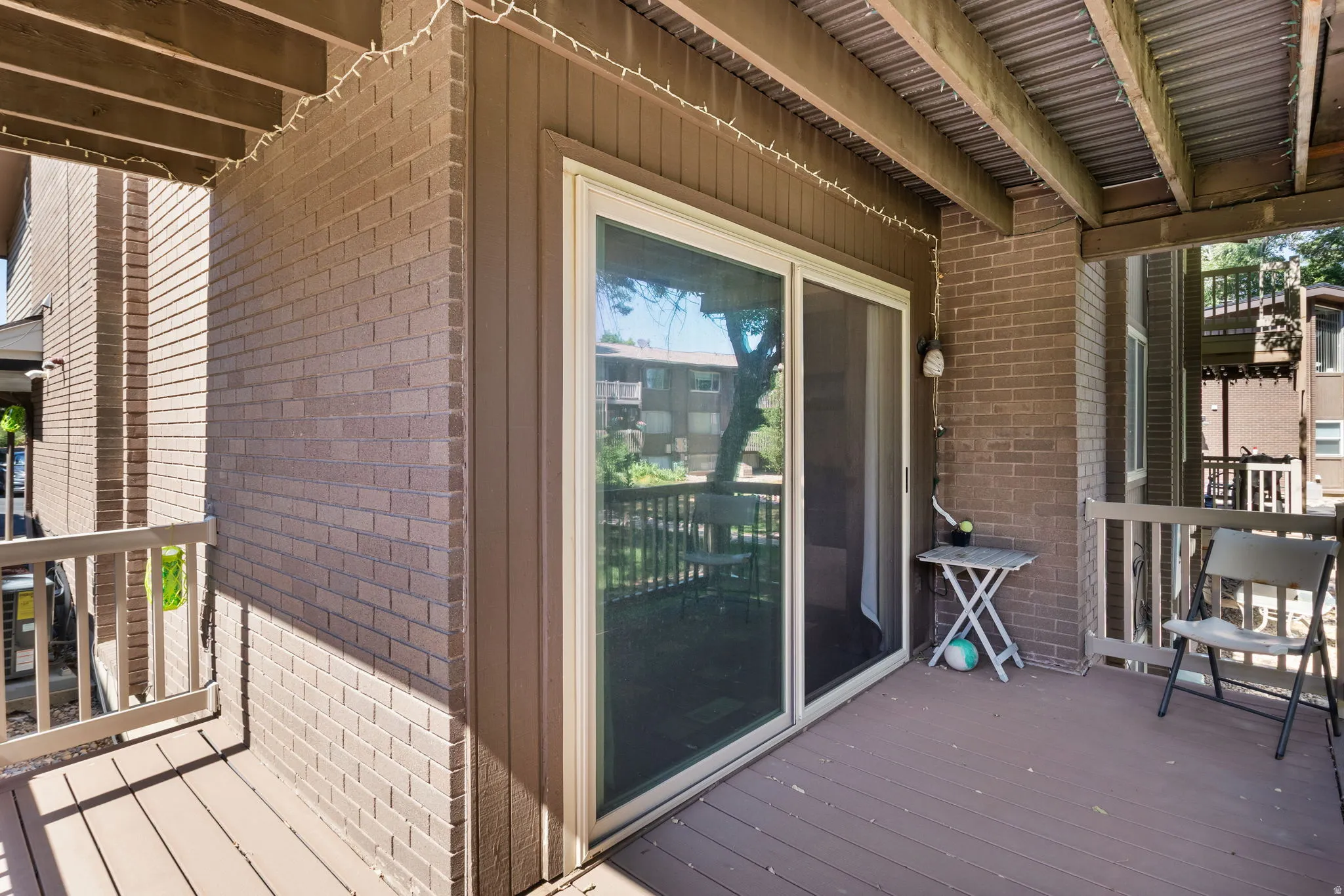 Outdoor patio featuring wood-finish decking and a sliding glass door