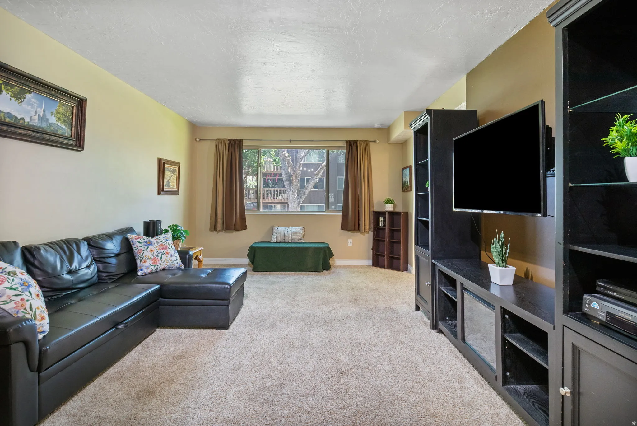 Spacious living area featuring neutral carpeting and light-toned walls