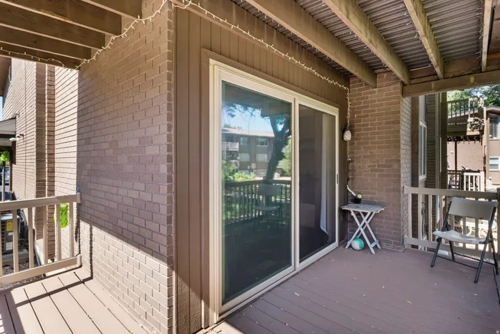 Outdoor patio featuring wood-finish decking and a sliding glass door