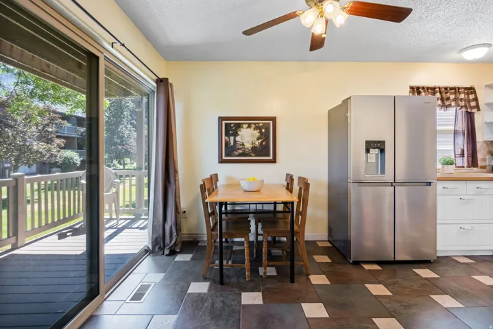 Dining area featuring patterned tile flooring and a ceiling fan with integrated lighting