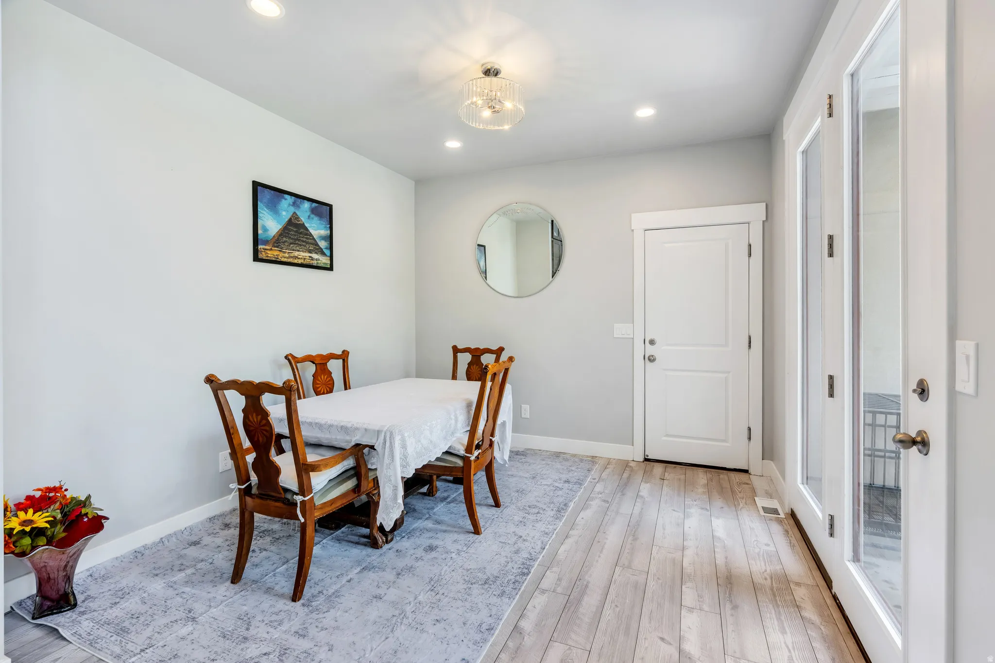 Dining area featuring wood-finish flooring, recessed lighting, and a decorative ceiling fixture