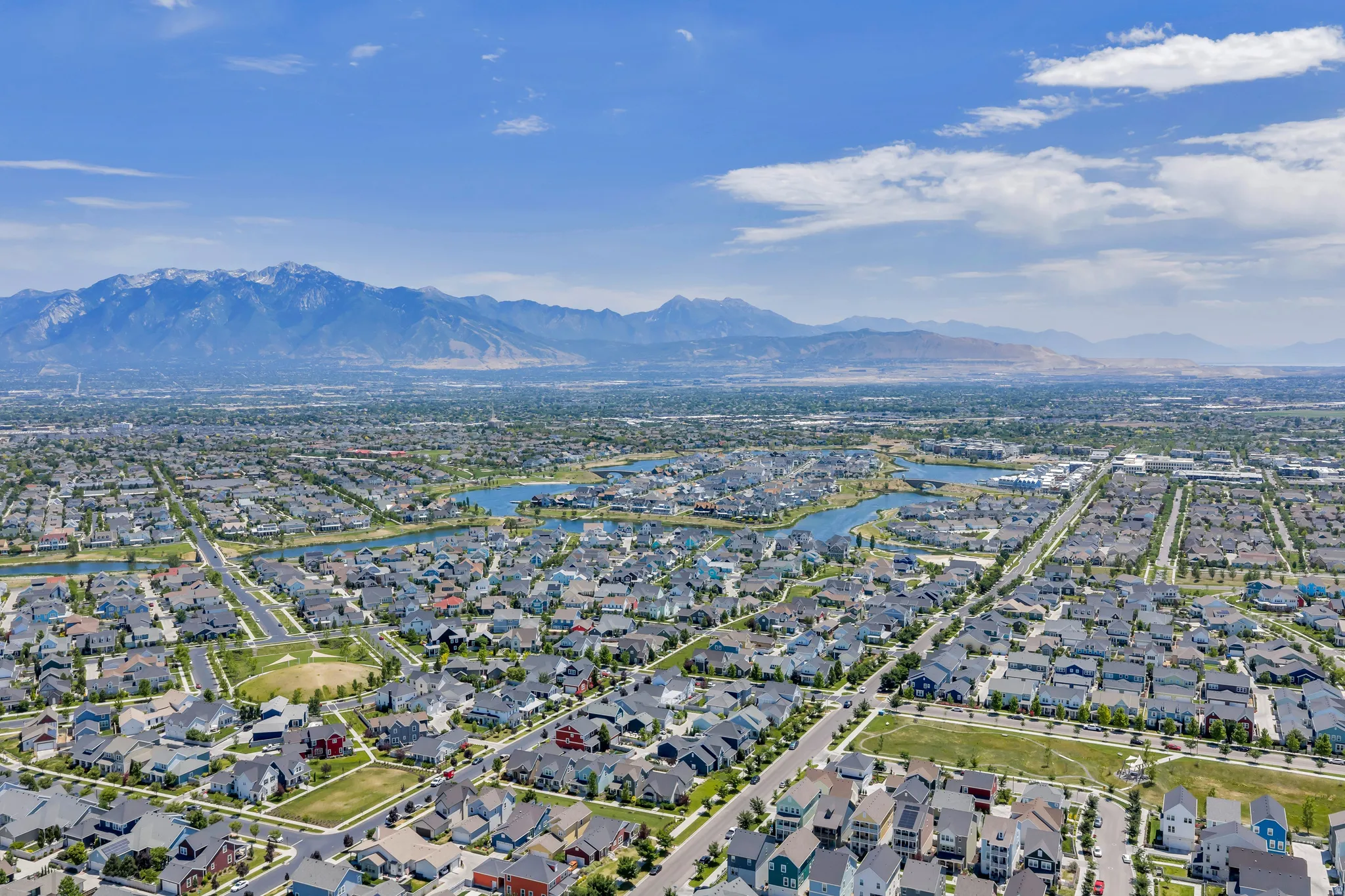 Expansive aerial perspective showcasing a residential development with multiple lakes and mature trees