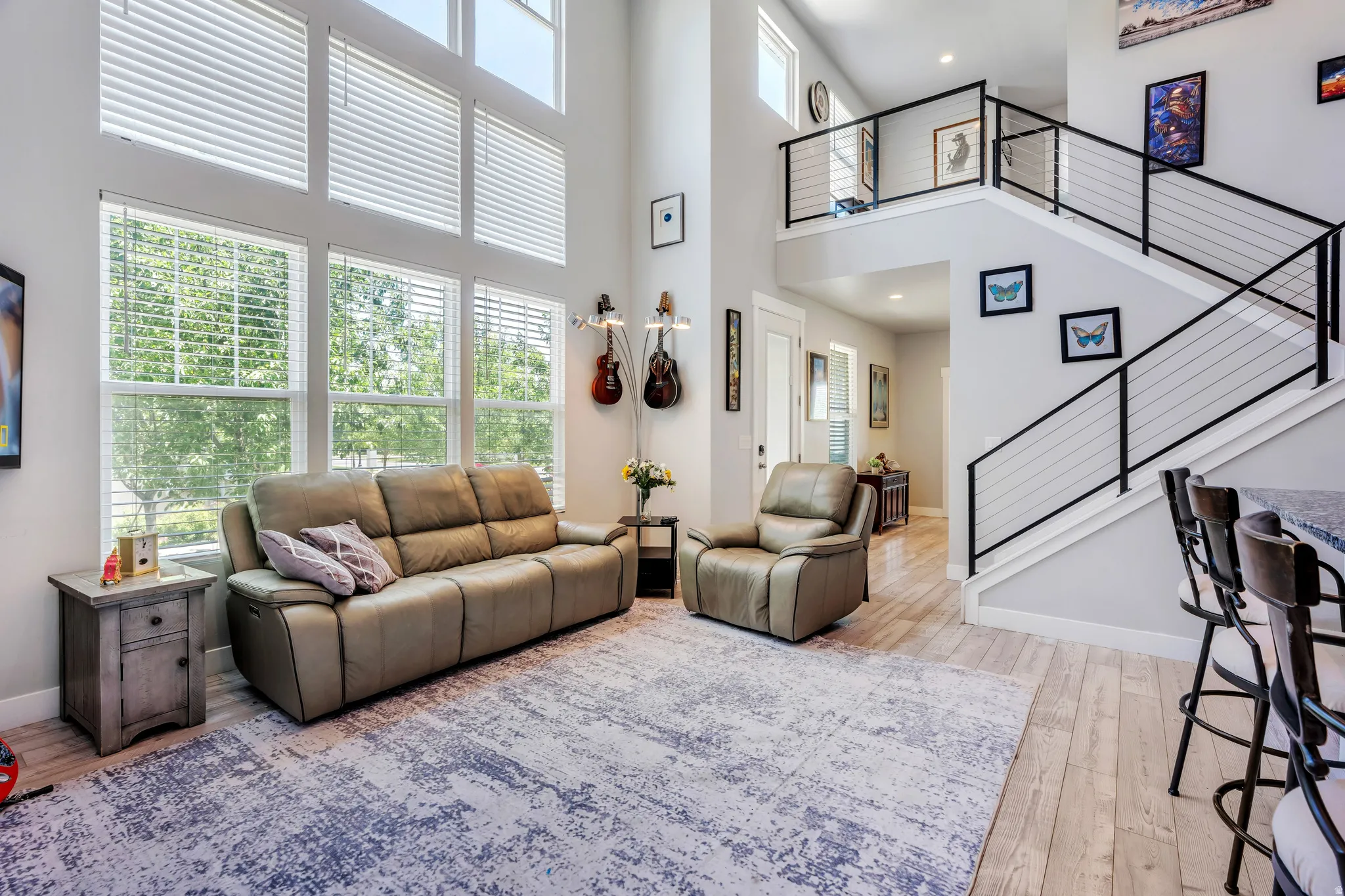 Two-story living area featuring a vaulted ceiling and extensive fenestration with horizontal blinds