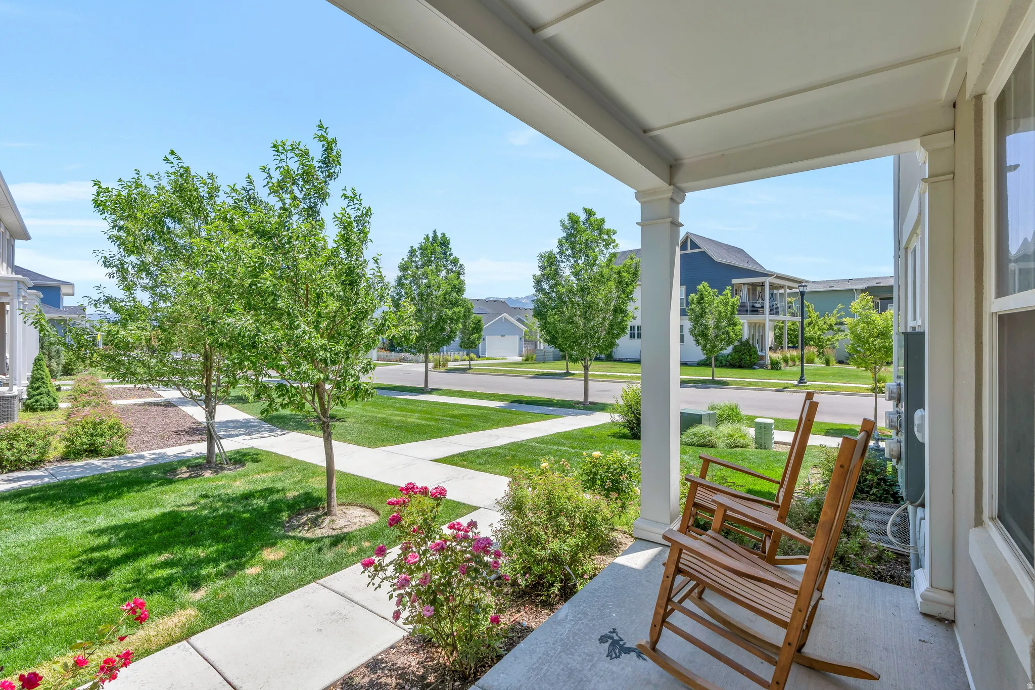 Covered front porch featuring white columns and a concrete floor