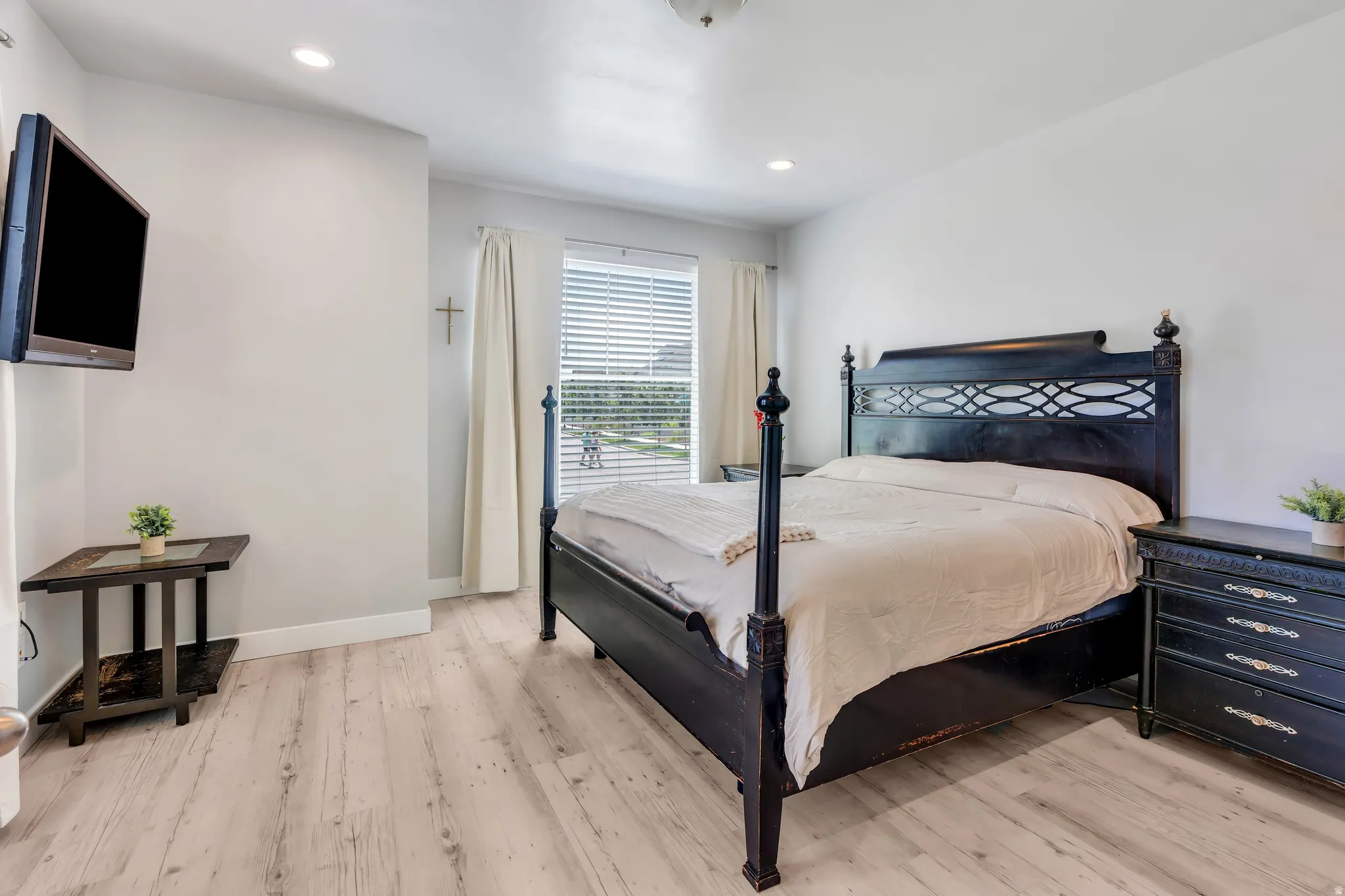 Bedroom featuring light wood-finish flooring, recessed lighting, and a large window with blinds