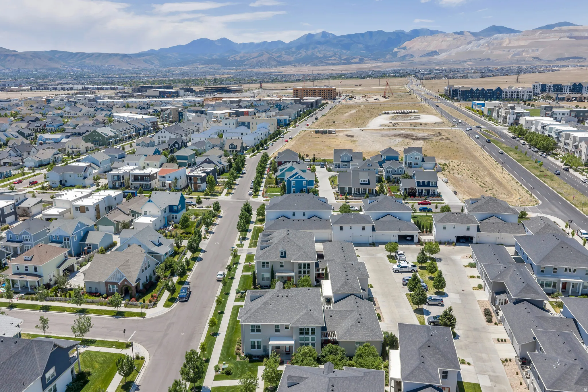 Expansive residential development featuring a variety of architectural styles, street parking, and mature street trees