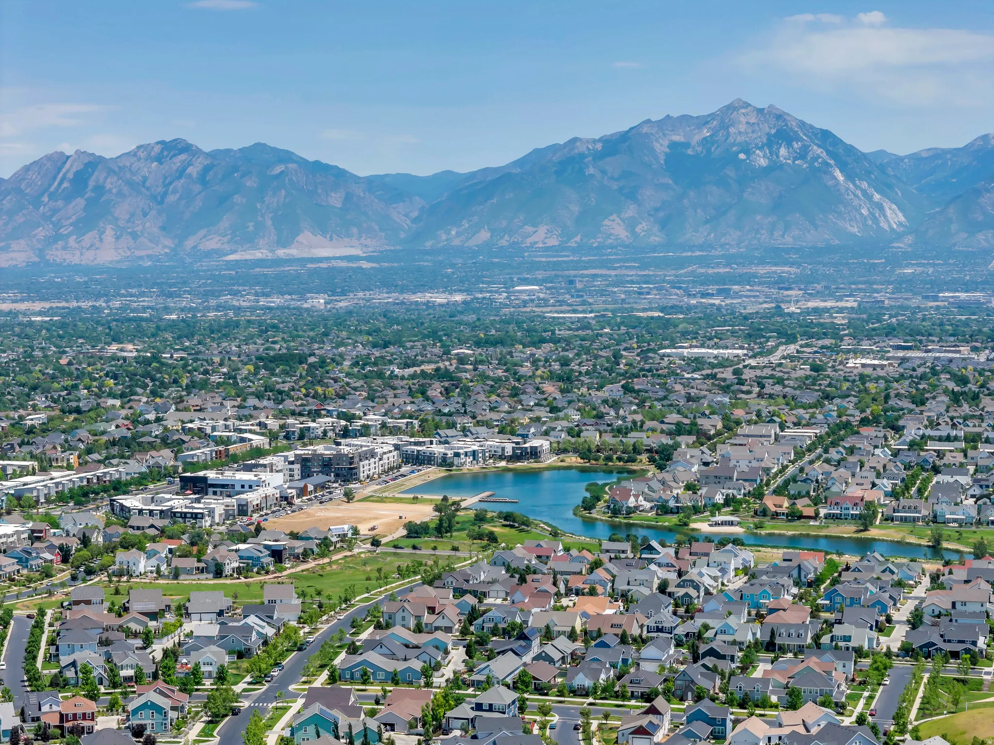 Expansive community featuring diverse residential architecture, a prominent central lake, and integrated green spaces