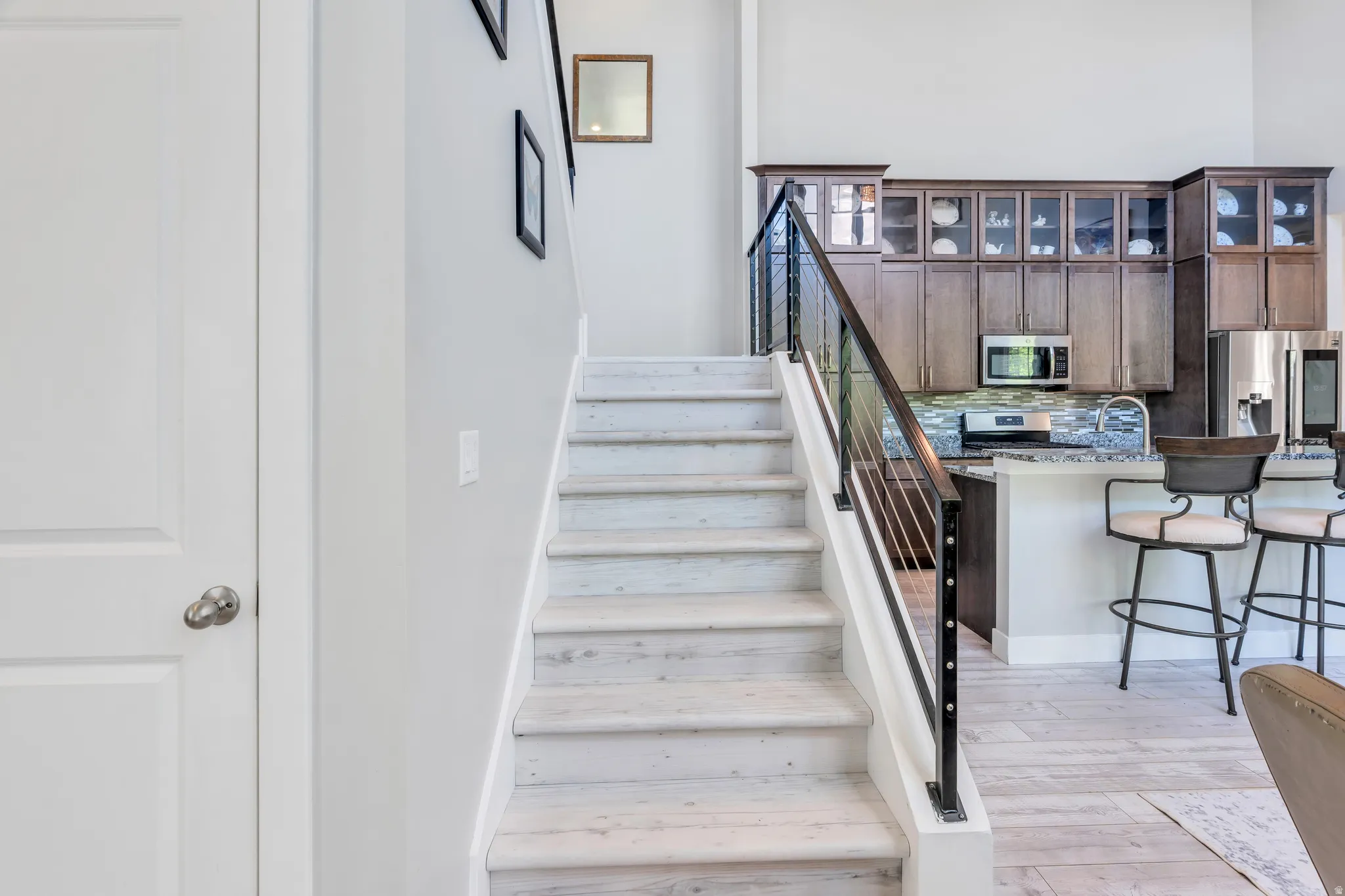 Light-toned wood-finish staircase with contemporary metal and wood railing