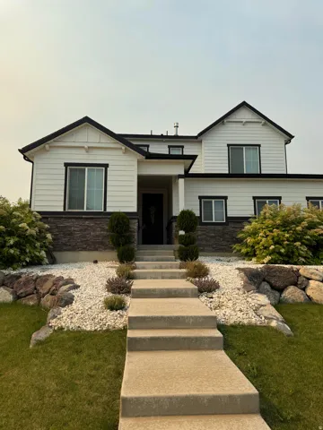 Contemporary two-story residence with white siding and dark trim