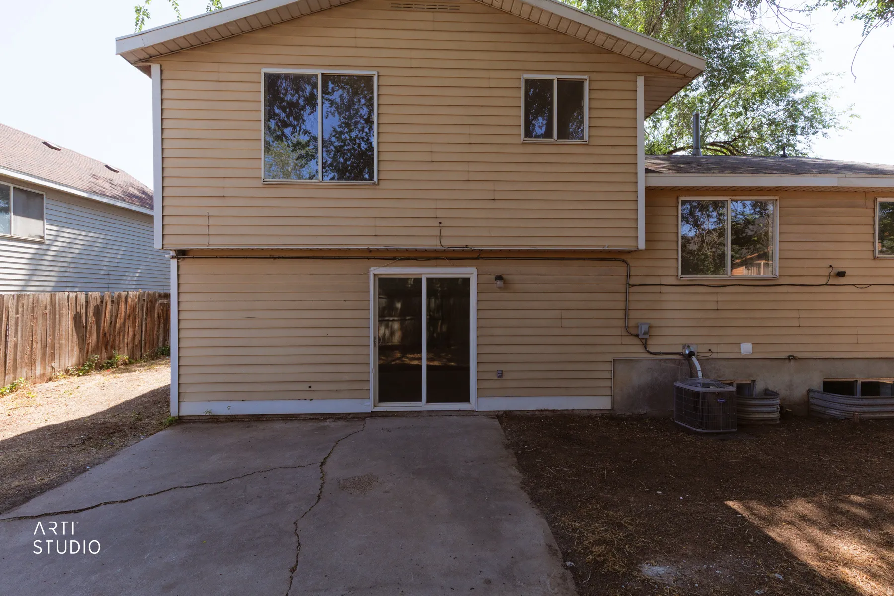 Two-story exterior with horizontal siding, multiple windows, and a ground-level sliding glass door