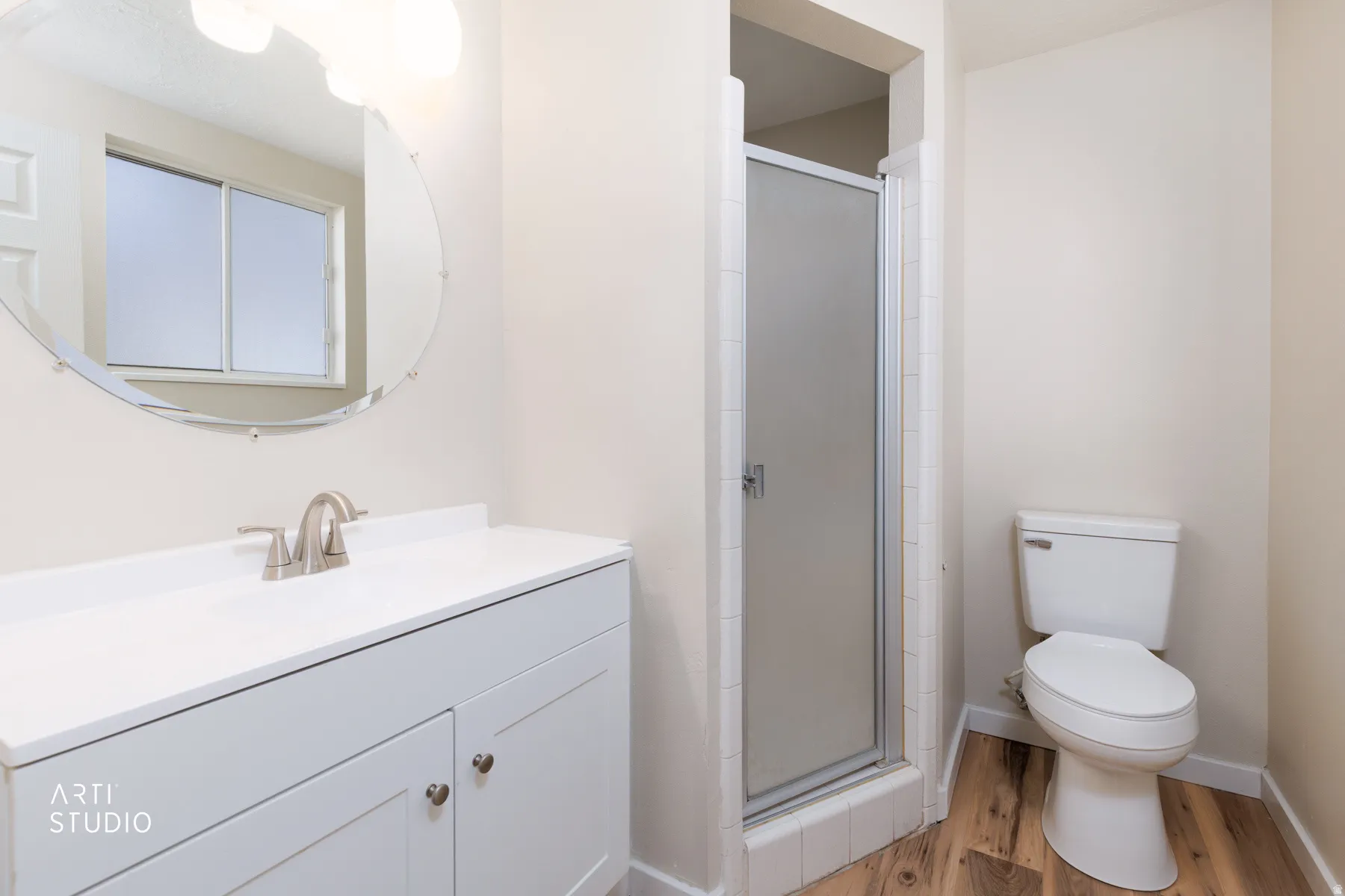 Master Bedroom Bathroom featuring a white vanity with a single basin sink, brushed nickel faucet, and a large round mirror