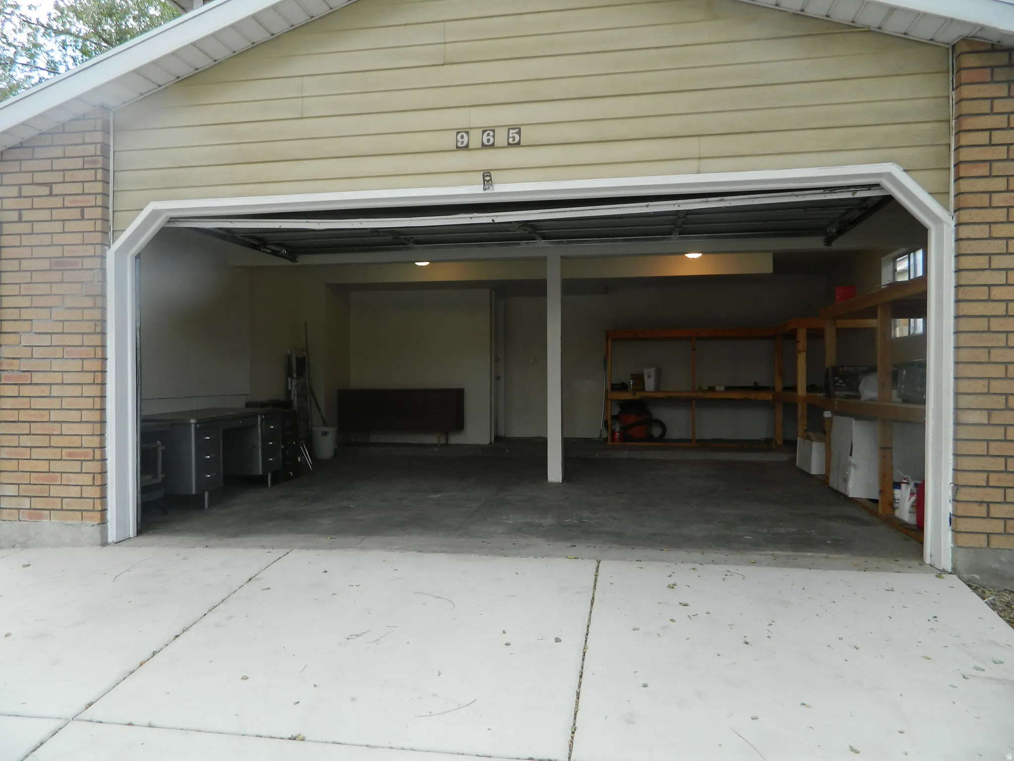 Attached garage featuring a concrete floor, exposed ceiling joists, and recessed lighting