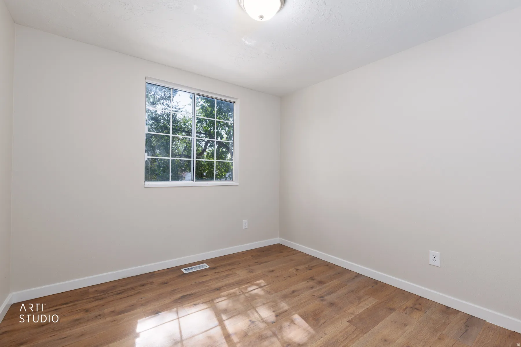 Room featuring wood-finish flooring and a neutral color palette