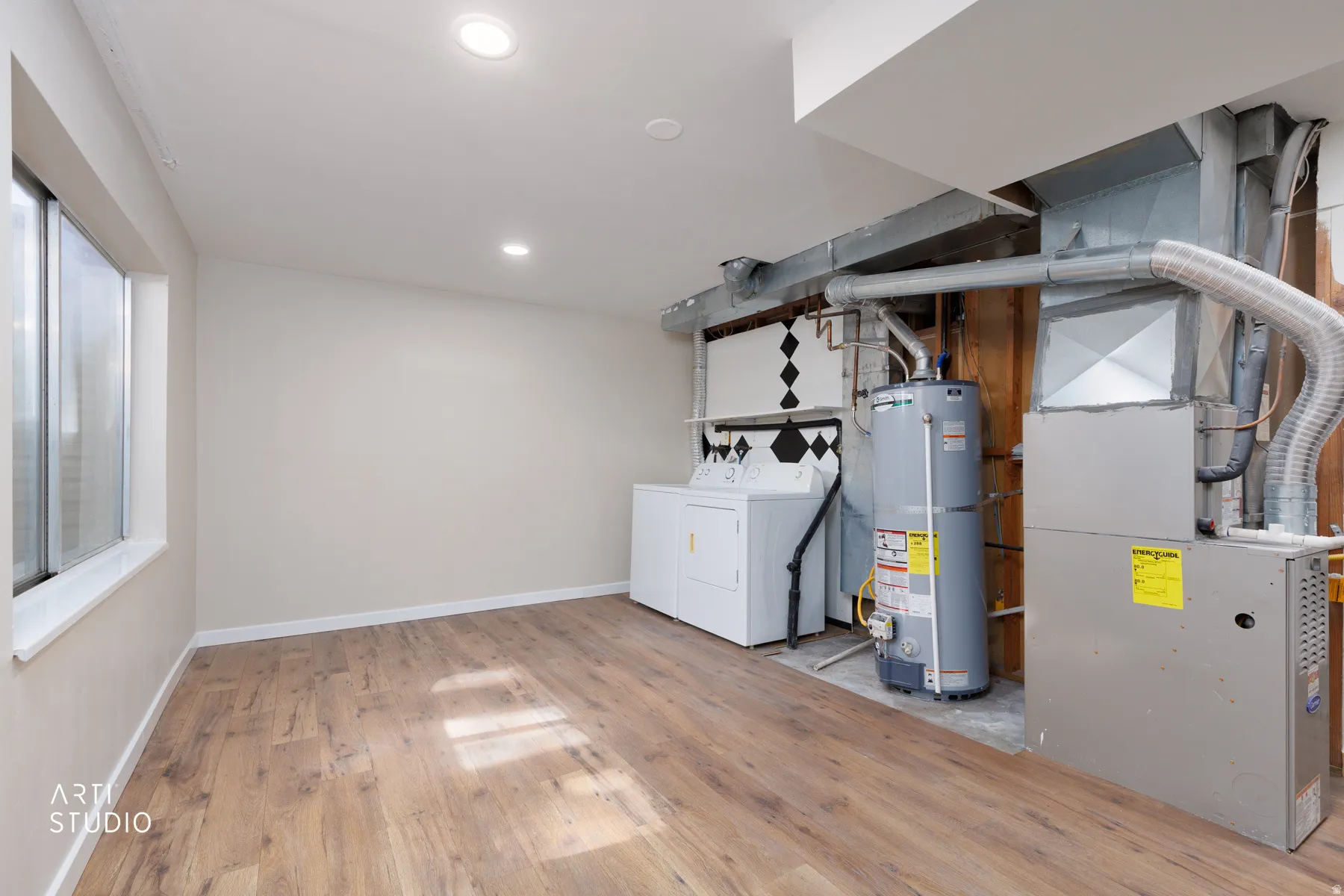 Finished basement space featuring wood-finish flooring, recessed lighting, and a large window