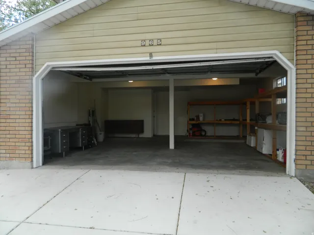 Attached garage featuring a concrete floor, exposed ceiling joists, and recessed lighting
