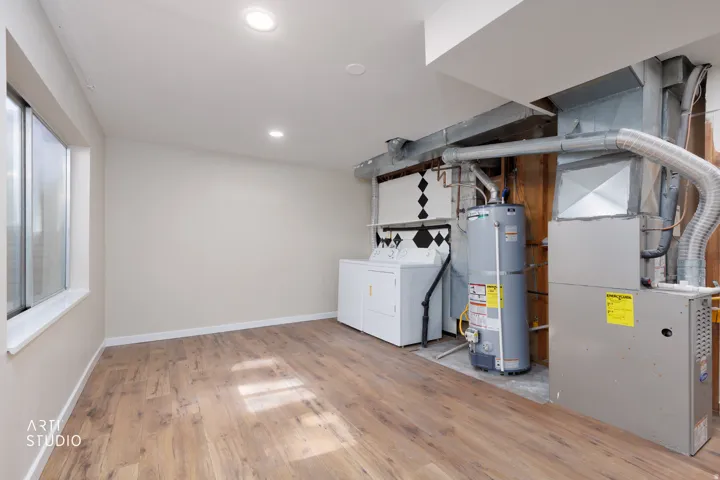 Finished basement space featuring wood-finish flooring, recessed lighting, and a large window