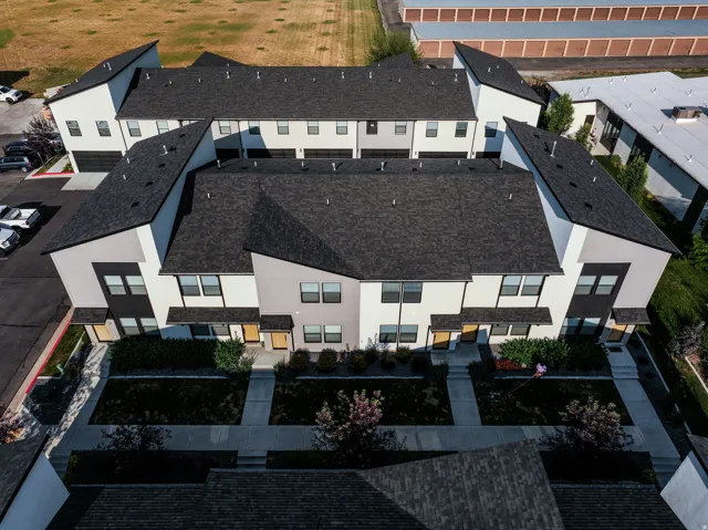 Modern multi-level townhomes featuring dark asphalt shingle roofing and light-toned siding