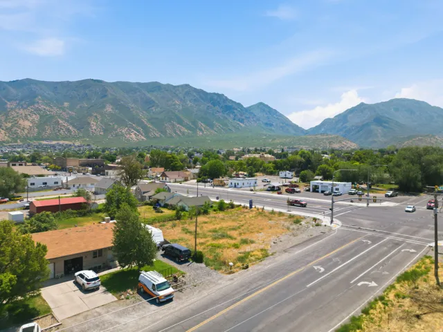 Expansive undeveloped lot presenting clear land, a paved roadside, and a mountain backdrop
