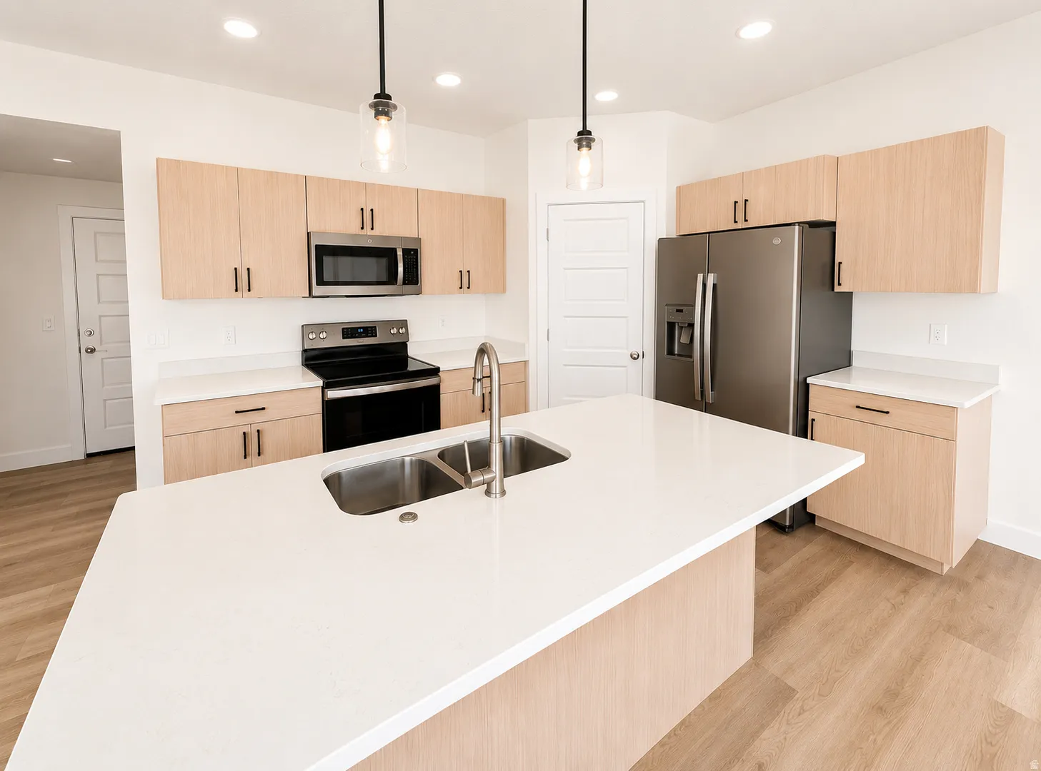 Contemporary kitchen with a central island featuring an undermount double basin sink and a single-handle pull-down faucet