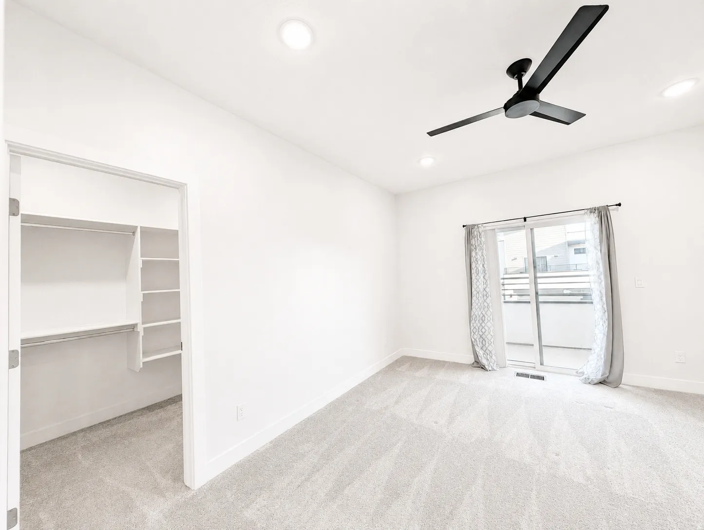 White-walled room featuring light-toned carpet, a ceiling fan, and recessed lighting